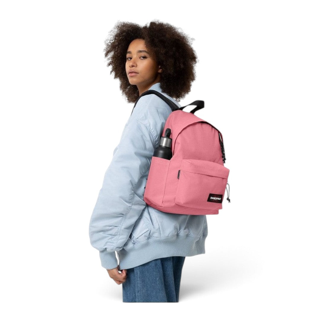 Model wearing a pink Eastpak Day Pak'r backpack with a water bottle, sold by Quiscuola.it – Zaini, Astucci e Diari Scuola